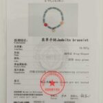 A gemstone testing certificate for the Teal Green Jadeite Bracelet – Disc Beads with Trio Charms, featuring a photo, official stamps, barcode, and detailed specs in Chinese and English.