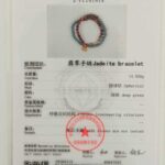 A gemstone certificate featuring a photo of the Sandalwood & Green Jadeite Double-Strand Bracelet—round beads with pouch charm—plus details like weight, shape, color, test results, official stamps, and serial numbers.