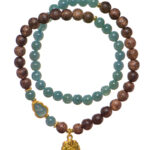 The Sandalwood & Green Jadeite Double-Strand Bracelet features round green jadeite and brown sandalwood beads with gold accents, a pouch charm, and a decorative green stone. Both strands are coiled together on a white background.