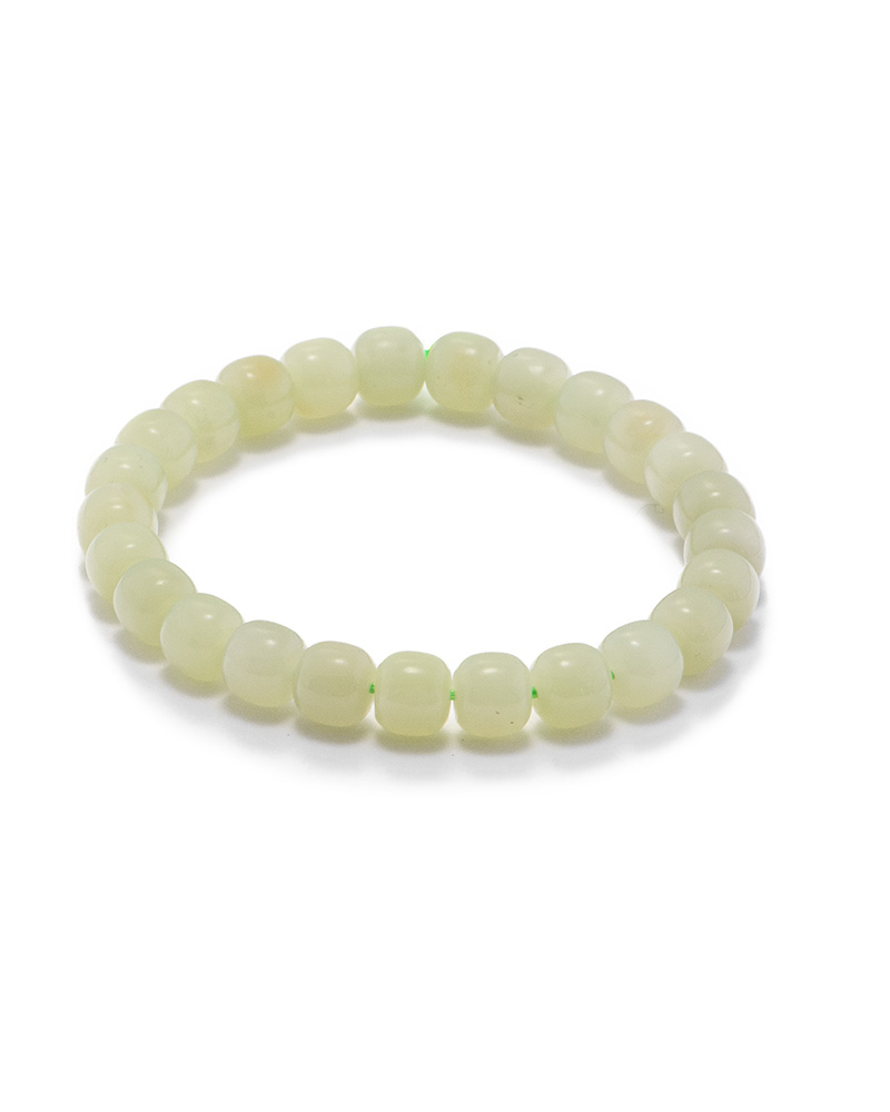 LYU_3818 Studio photo of a pale cream Nephrite (soft jade) bracelet, featuring drum-shaped beads with a soft-gloss polish, on a white background.