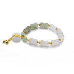Studio photo of a white Quartzite jade bracelet, featuring carved pillow beads with pale green transitions and gold-tone accents with a tassel-style charm drop, on a white background.