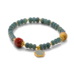 Studio photo of a deep green Jadeite bracelet, featuring disc beads with gold-tone spacers and a carved floral charm, on a white background.