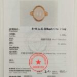 A certification card with photo shows details of the Hetian White Nephrite Jade Ring – Oval Cabochon, Gold-Tone Filigree Setting (4.396g), test results, and a red authenticity stamp from NGTC testing center.