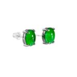 Pair of vivid green jadeite oval cabochon stud earrings in high-polish sterling silver with four-prong baskets and butterfly backs on white background