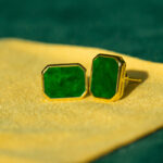 Vivid Green Jadeite Stud Earrings – Rectangular Flat Inlay, set in gold-plated 925 sterling silver, are displayed on yellow fabric with a green background.