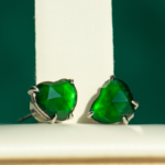 A pair of Vivid Green Jadeite Stud Earrings with heart-cut custom faceting in 925 sterling silver, displayed upright against a white and green background.