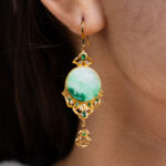A close-up shows an ear adorned with the Jadeite Drop Earring—Chinese-inspired filigree, gold-plated 925 sterling silver—with green gemstones and a large circular jadeite stone at the center.
