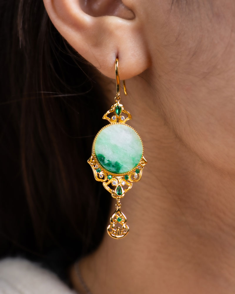 A close-up shows an ear adorned with the Jadeite Drop Earring—Chinese-inspired filigree, gold-plated 925 sterling silver—with green gemstones and a large circular jadeite stone at the center.