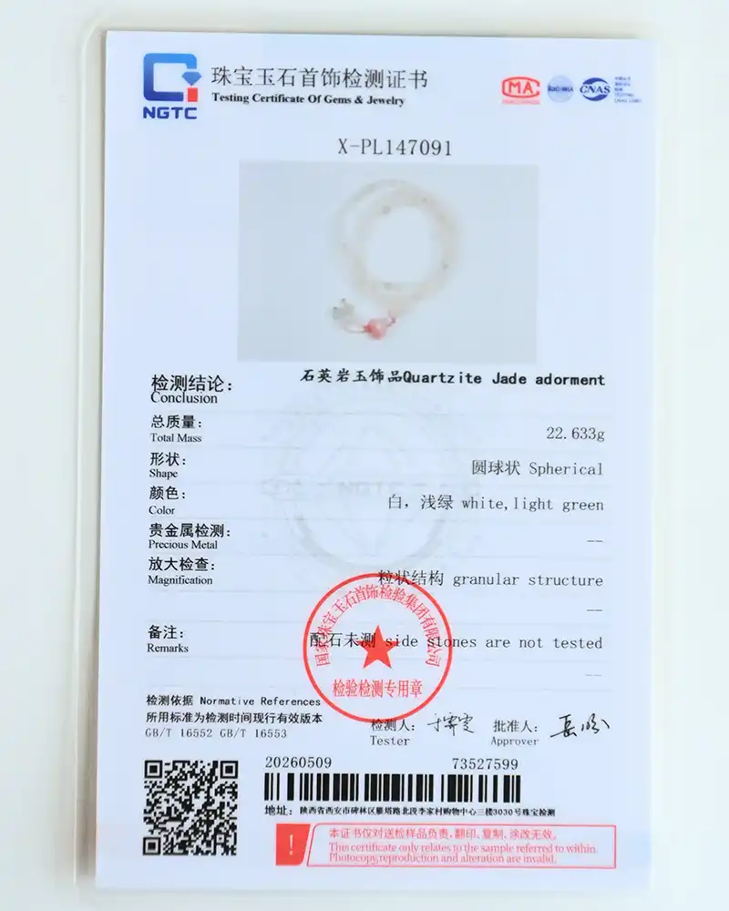DSC_0133 A gemstone testing certificate with Chinese and English text, showing details for a spherical Quartzite Jade adornment, weighing 22.633g, with descriptions, a photo of the item, official seals, and a barcode at the bottom.