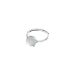 A silver ring with a round, pale, translucent gemstone set in a simple prong setting, displayed on a white background.