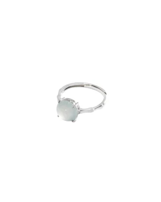 A silver ring with a round, pale, translucent gemstone set in a simple prong setting, displayed on a white background.