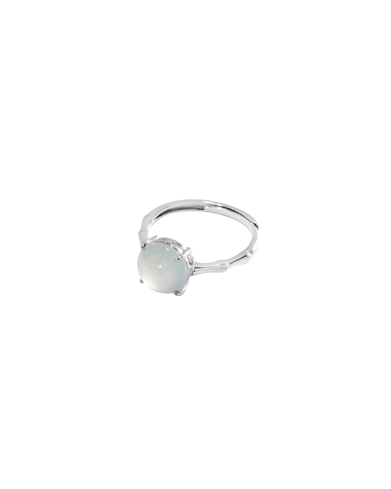 DSC_0179 拷贝 A silver ring with a round, pale, translucent gemstone set in a simple prong setting, displayed on a white background.