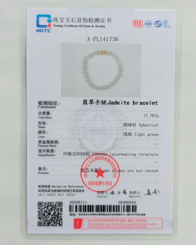 IMG_20260115_153707 A gem testing certificate for a jadeite bracelet shows a photo of a light green, spherical bead bracelet, technical details in English and Chinese, a red stamp, and official logos at the top of the document.