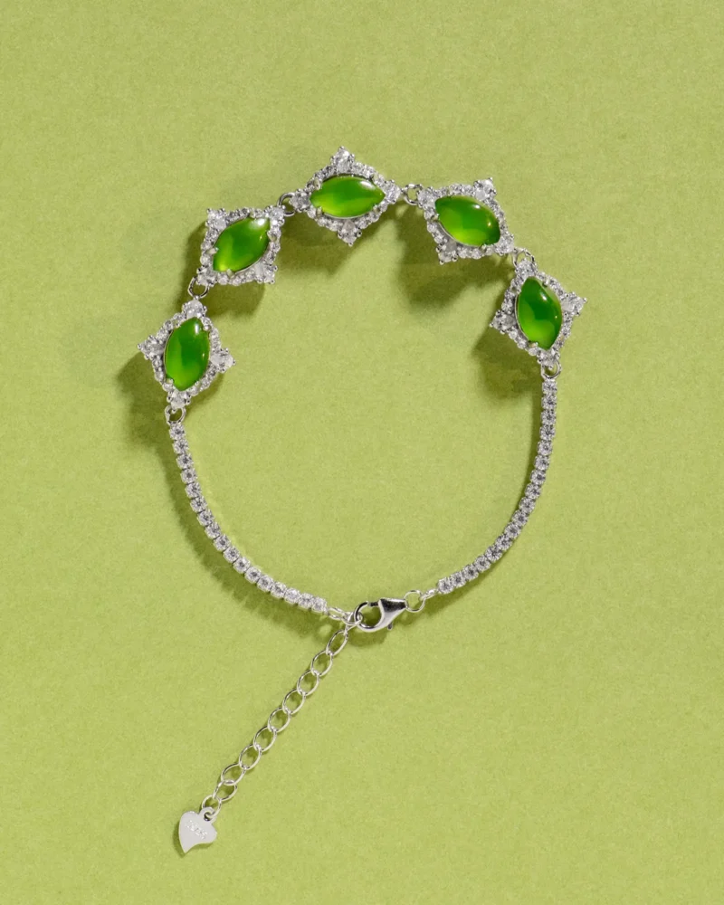 Introducing the Green Nephrite Jade Bracelet — Marquise Cabochon Link Line: a stunning silver bracelet featuring five marquise-shaped green nephrite jade cabochons set in elegant links and finished with a secure chain clasp, showcased against a light green background—perfect for anyone who values refined nephrite jade jewelry.