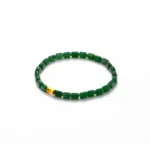 A simple beaded bracelet with dark green cylindrical beads and one contrasting gold bead, displayed on a plain white background.