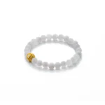 A beaded bracelet made of round, white stones with a single decorative gold bead, displayed on a white background.