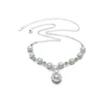 White jadeite necklace with oval cabochons and green accents on white background