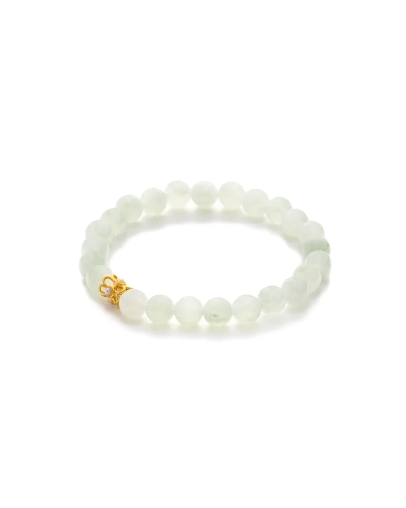 The Light Green Jadeite Bead Bracelet — Spherical Beads with Gold-Tone Detail features round, light green jadeite beads accented by a single gold-tone decorative bead, and is elegantly presented on a white background.