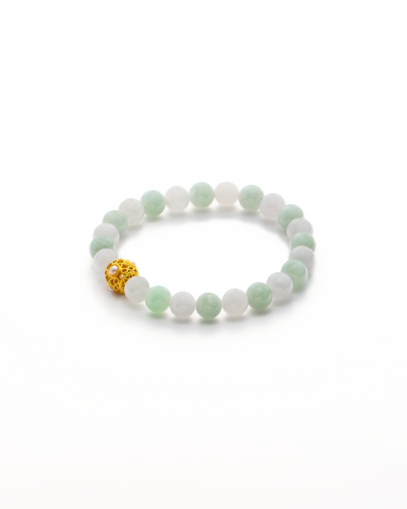 A beaded bracelet with alternating light green and white jade beads, featuring a single gold filigree bead, displayed on a white background.