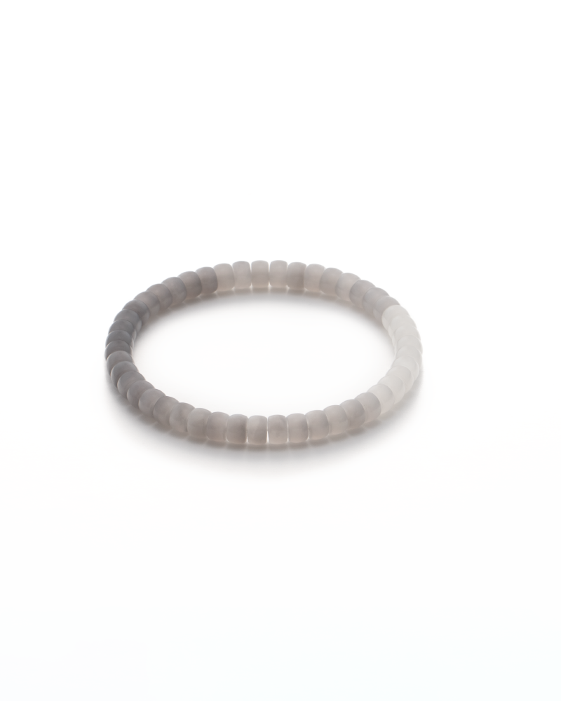 DSC_0161 拷贝 A simple, round bracelet made of smooth, light gray beads is displayed on a white background.