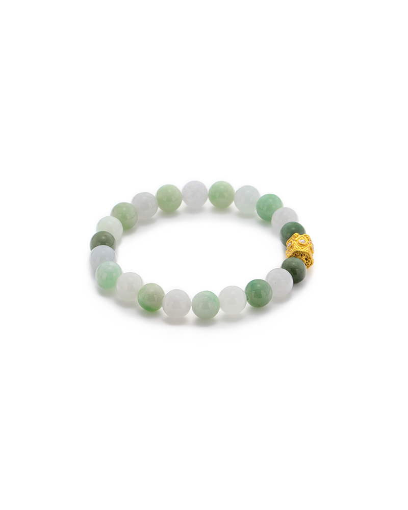 DSC_0502 拷贝 A beaded bracelet made of round, light green and white jade stones, featuring one gold bead with intricate detailing, arranged in a circle on a white background.