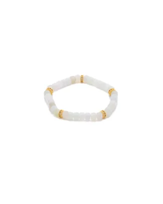 A beaded bracelet made of translucent white stones with four gold accent spacers evenly placed around it, displayed on a white background.
