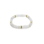 A beaded bracelet made of translucent white square beads, accented with small gold and green spacer beads, displayed on a plain white background.