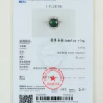 A gemstone testing certificate displaying details and an image of a jadeite ring with a round green stone set in a silver band, test results, measurements, and official stamps.