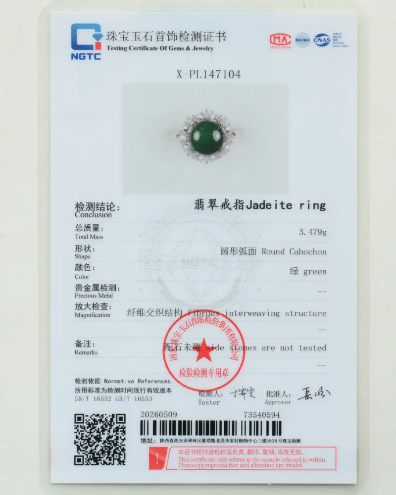 DSC_0797 拷贝 A gemstone testing certificate displaying details and an image of a jadeite ring with a round green stone set in a silver band, test results, measurements, and official stamps.