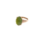 A gold ring with a large oval green gemstone set in the center and small accent stones along the band, displayed on a white background.